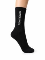 Black knee-high sock on a leg, featuring white vertical branding text along the side (product shot).
