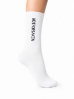 White knee-high sock on a leg with vertical black text reading 'NOT FOR SAKEN' along the side.
