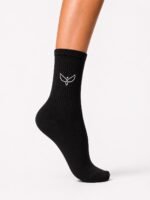 Black ribbed mid-calf sock on a leg with a white wing-like logo on the side.