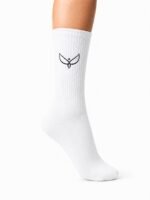 White knee-high sock on a leg with a small black bird logo on the shin area, ribbed texture visible against a white background
