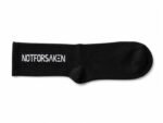 Black sock laid flat with white text reading 'NOT FOR SAKEN' along the cuff (branding visible).